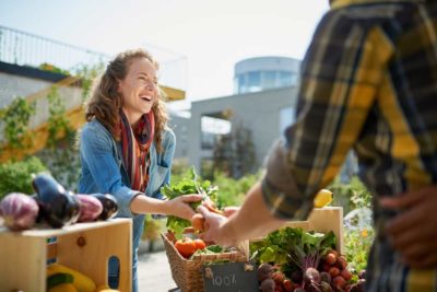 Azienda agricola, ragazza che vende frutta e verdura al banco