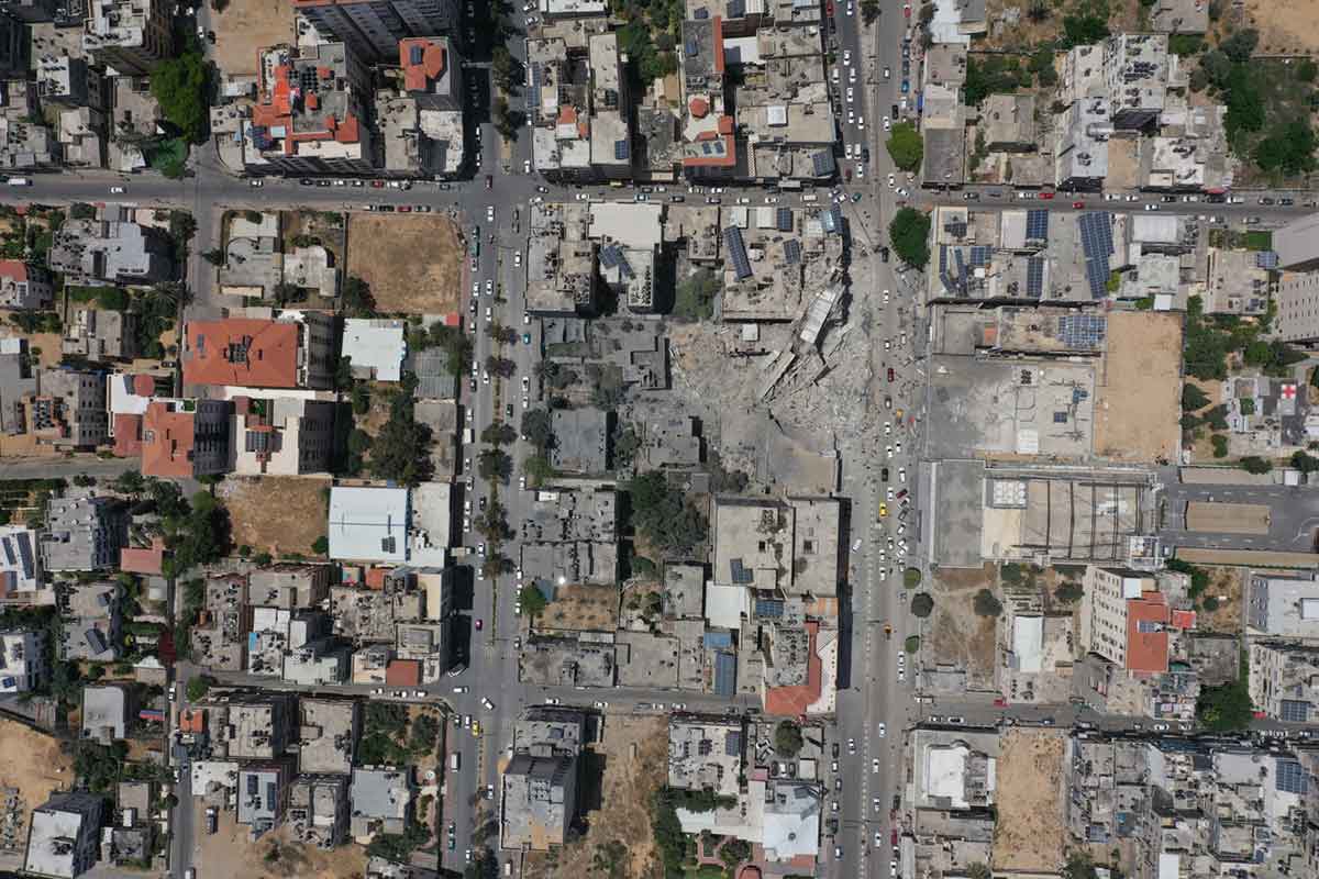 finanza esg e armi - Veduta aerea di un’area urbana con edifici distrutti e macerie in mezzo a costruzioni intatte.